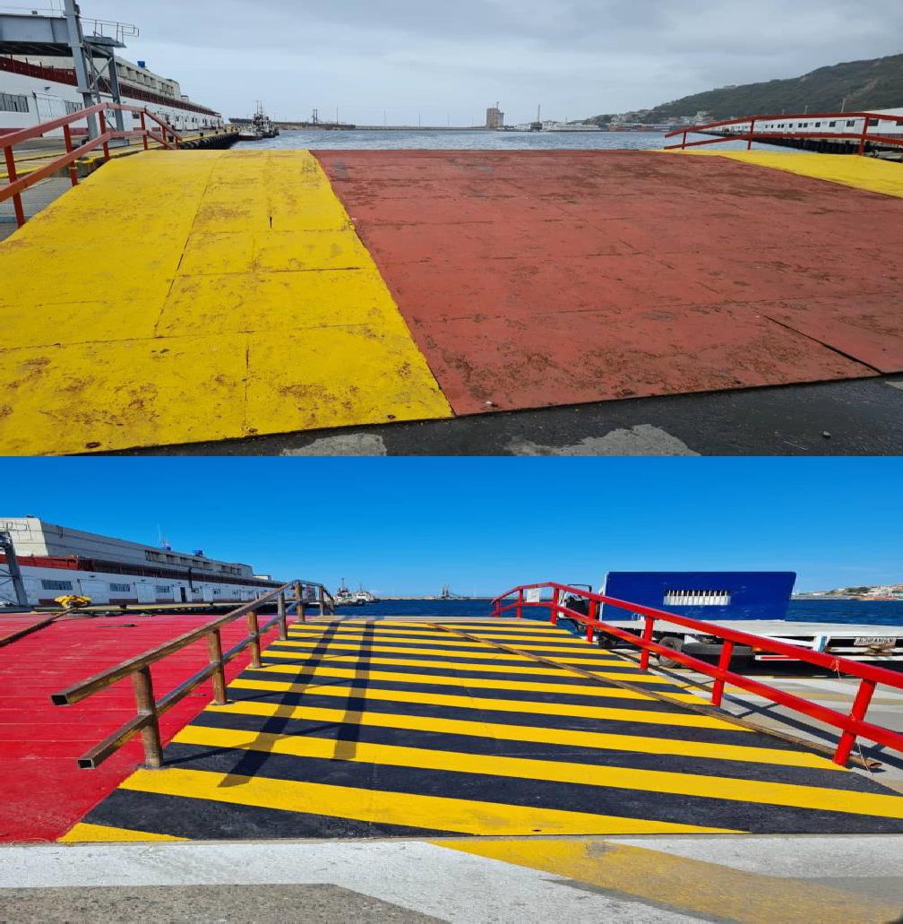 Rampa de acceso con demarcación vial amarilla y barandas metálicas