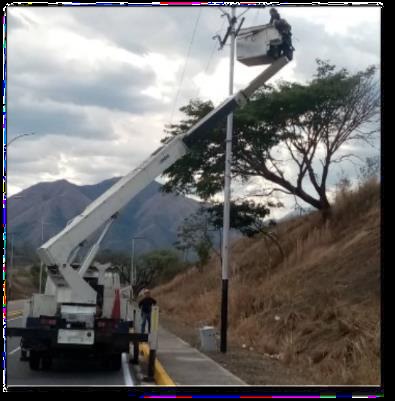 Camión con brazo elevador instalando postes de alumbrado público
